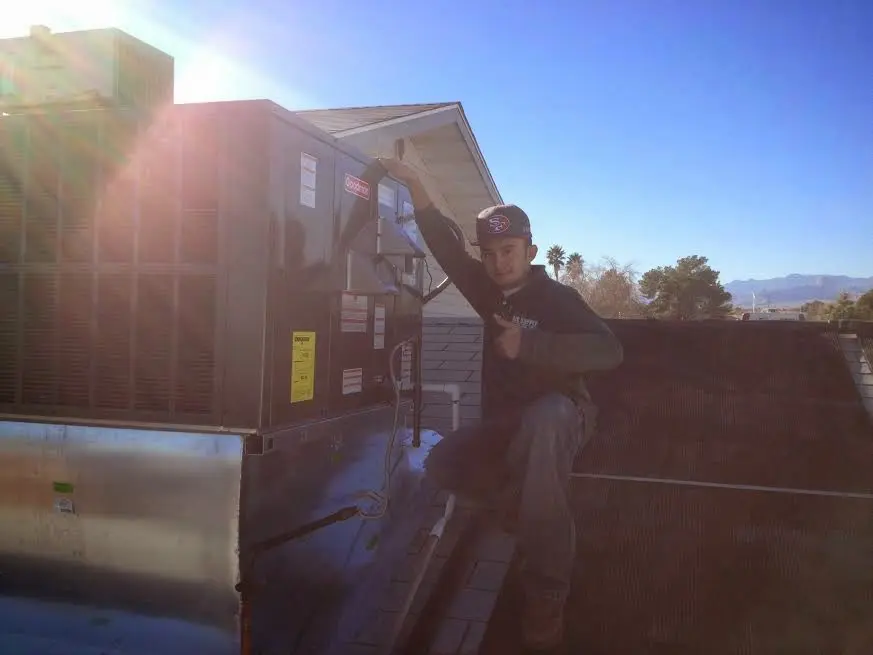 HVAC technician performing HVAC Inspection on a rooftop unit in Taylor
